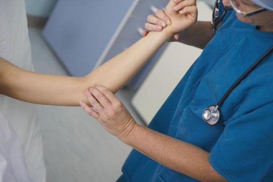 Врач осматривает руку